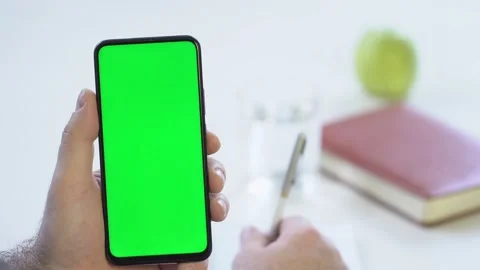 Close-up shot of green screen template smartphone in male hands at home offise Stock Footage 142877186