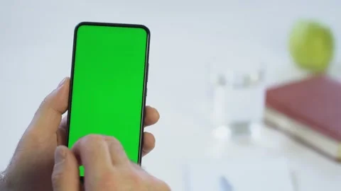 Close-up shot of green screen template smartphone in male hands at home offise Stock Footage 143441113