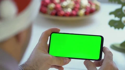 Close-up shot of green screen template smartphone in male hands at home offise Stock Footage 143589756