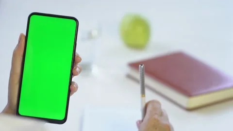 Close-up shot of green screen template smartphone in female hands at home offise Stock Footage 143590364