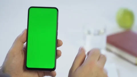 Close-up shot of green screen template smartphone in male hands at home offise Stock Footage 143590466