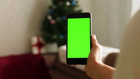 Close-up shot of green screen template smartphone in hands in Christmas interior Stock Footage 164583683