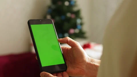 Close-up shot of green screen template smartphone in hands in Christmas interior Stock Footage 164584239