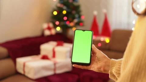 Close-up shot of green screen template smartphone in female hands in Christmas Stock Footage 164597831