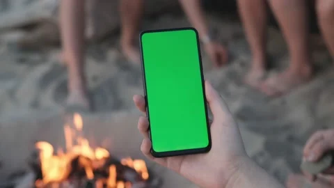 Close-up shot of green screen template smartphone in female hands on the beach Stock Footage