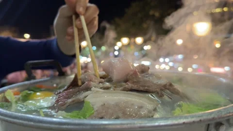 Close up shot grilled pork buffet hot steam at night. Chopstick flipping pork. Stock Footage 310286993