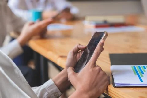 Close-up shot of group of people using smart phone while sitting together Stock Photos