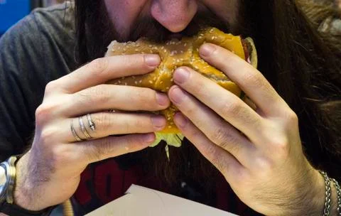 Close-up shot of guy eats hamburger  Stock Photos
