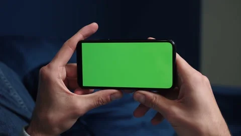 Close up shot of guy lying on couch at night, holding a smartphone with chroma Video stock 144145590
