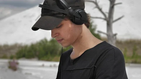 A close-up shot of a guy making music at a DJ set in the middle of a desert Stock Footage 172315323