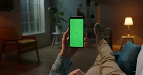Close up shot of guy relaxing on couch at night, using smartphone with chroma Stock-Footage 133527858