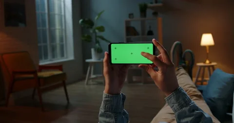Close up shot of guy using his horizontal smart phone with mock up green screen Stock-Footage 139770109