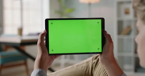 Close up shot of guy using a tablet computer with green mockup screen. Student Stock-Footage 139937087