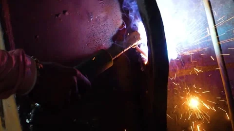 Close-up shot of A guy welding a big iron piece at a construction site, lots of  Stock Footage 321696875