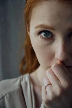 Close shot of half face of red-haired girl with blue eyes. A look into the frame Stock Photos