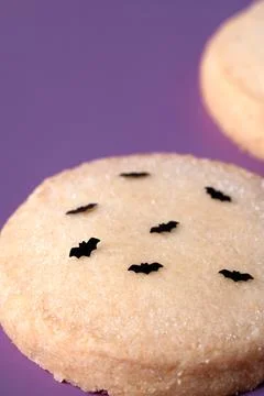 Close up shot of Halloween shortbread cookie decorated with black edible bats at Stock Photos