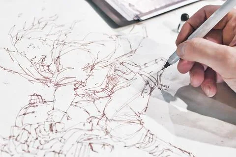 Close-up shot of the hand of a comic book artist painting a manga character Foto stock