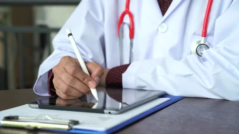 Close up shot hand of Doctors with stethoscope are using tablets to write tre Stock Footage 131927731