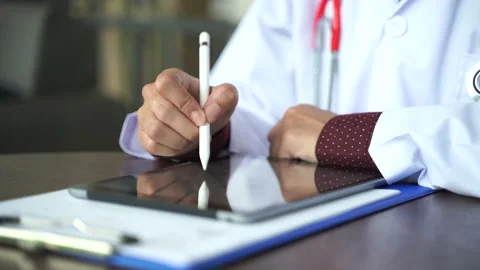Close up shot hand of Doctors with stethoscope are using tablets to write tre Stock Footage 131928268