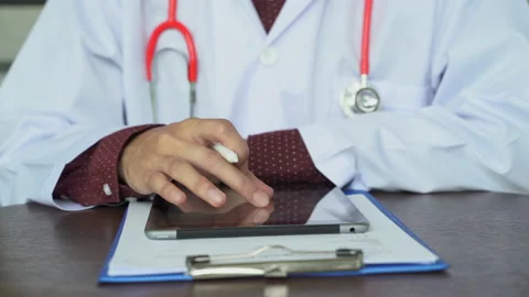 Close up shot hand of Doctors with stethoscope are using tablets to write tre Stock Footage 131928638