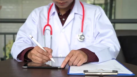 Close up shot hand of Doctors with stethoscope are using tablets to write tre Stock Footage 131929168
