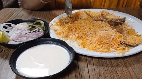 Close up shot of a hand eating mutton briyani Rice with salad and curd Stock Footage 163155931