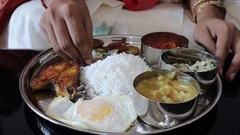 Close up shot on a hand eating a non vegeterian indian thali with rice and fish Stock Footage 127565007
