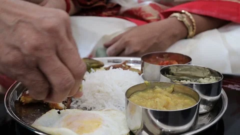 Close up shot on a hand eating a non vegeterian thali with rice and fish and dal Stock Footage 127565096