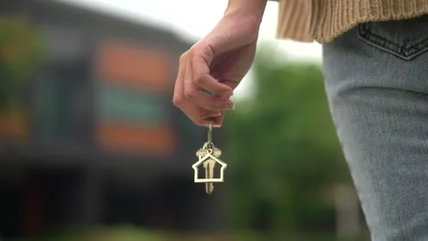 Close up shot of hand holding key woman buying or rent new home walking to new. Stock Footage 241997530