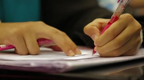 Close Up Shot of A Hand Holding A Red Pen and Writing Lecture Notes Stock Footage 49388539