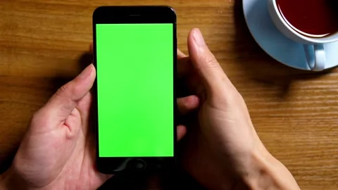 Close Up Shot of Hand of Man Holding his Smartphone with Green Screen click Stock-Footage 336585725