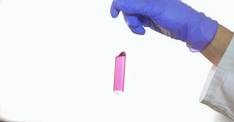 Close up shot of a hand mixing a test tube with red chemical in it Stock Footage 48979230
