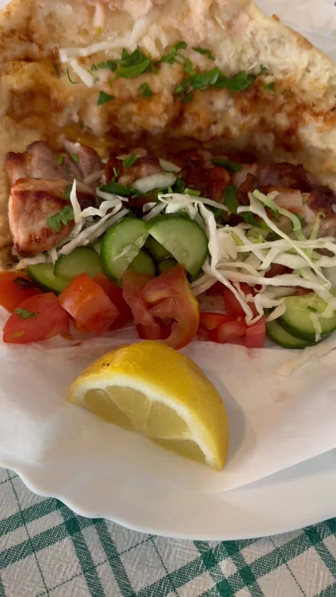 Close up shot of hand opening traditional cyprus pork gyros pita wrap with salad Stock Footage 337366660