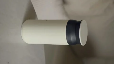 Close up shot of hand picking up white thermos from marble table in soft in.. Stock Footage 332208849