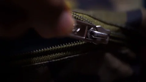 Close up shot of a hand pulling the zip to open a bag Video stock 92453927