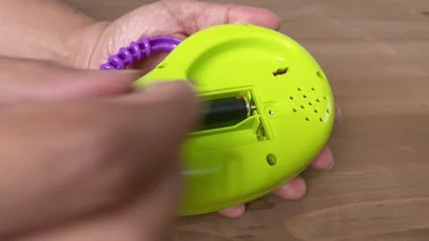 Close-up shot of hand putting the batteries into the toy 库存影片 345587384