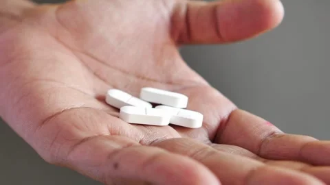 A close-up shot of hand showing white pills, motion footage with dynamic mo.. Vídeos de archivo 333030944