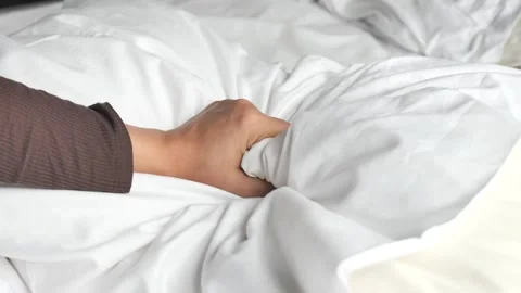 Close up shot of a hand in soft white sheets, gentle motion creating texture. Stock Footage 332745530