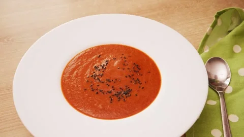 Close up shot of hand sprinkling black sesame seeds over creamy tomato Stock Footage 344886162