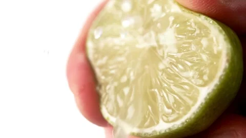 Close up shot of Hand squeezing a slice of lime. Hand Squeezing a Piece of Fresh Stock-Footage 336588920