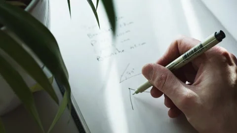 Close up shot of a hand trying to solve a geometry problem in a notebook Stock Footage 247985754