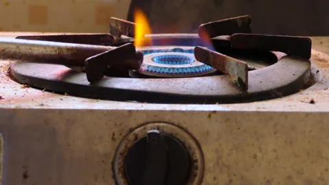 Close shot of hand turning on the knob of a dirty stove and and igniting it Stock Footage 146811096