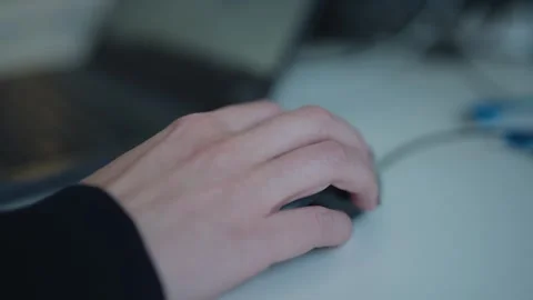 Close-up shot of a hand using a computer mouse at a desk during office work in Stock Footage 334024542