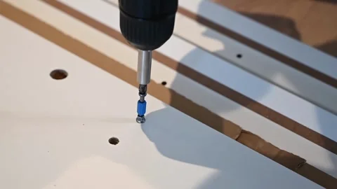 Close-up shot of a hand using a power drill to screw into a white surface w.. Stock Footage 339347518