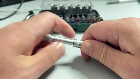 A close-up shot of hands assembling a screwdriver by inserting a magnetic s.. Stock Footage 323140925