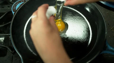 Close shot of hands cracking egg into hot frying pan in super slow-motion 스톡 동영상 60113753