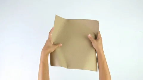 Close-up shot of hands crumpling brown paper isolated on a white background. Stock Footage 114558179