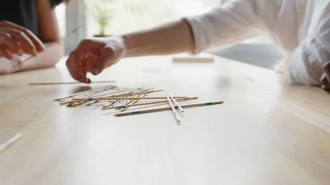 Close-up shot of hands of Diverse office team enjoys a lively Mikado board game Video stock 335746727