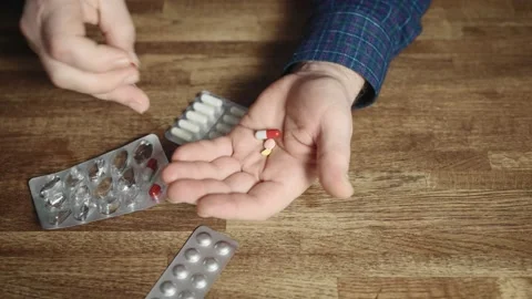 In a close-up shot, the hands of an elderly man who is preparing to take Stock Footage 234869037