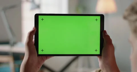 Close up shot of hands holding a tablet computer with green mock up screen. A Stock-Footage 135358088
